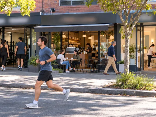 A person running past an unlettered gym, café and treatment-room strip